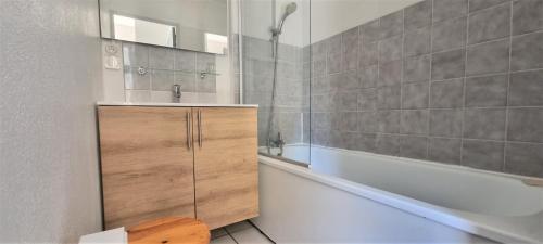 La salle de bains est pourvue d'une baignoire blanche, d'un lavabo et d'une baignoire. dans l'établissement Les pieds dans l'eau !, à Cerbère