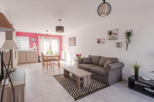 un salon avec un canapé et une table dans l'établissement L'ORCHIDEE - T3Proche plagewifi, à Saint-Nazaire