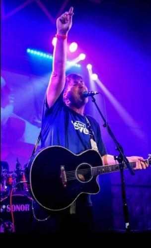 a man with his hand in the air on a guitar at The Fox Inn, Wilbarston in Wilbarston