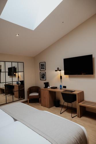 a bedroom with a bed and a desk and a television at Hotel & Spa Convento San Francisco in Soria