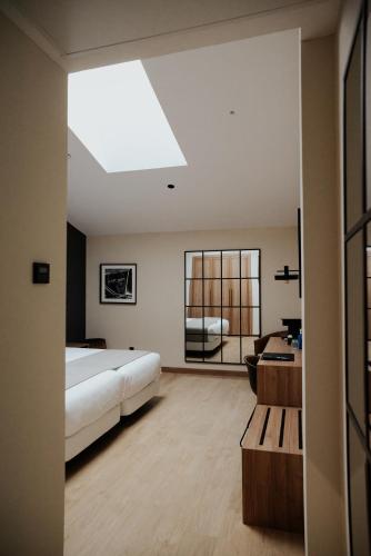 a bedroom with a bed and a desk and a window at Hotel & Spa Convento San Francisco in Soria