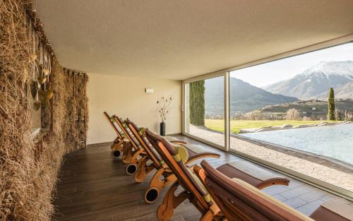 a row of chairs in a room with a large window at Hotel Mitterplatt (Schenna Resort) in Schenna