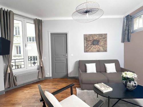 salon z kanapą i stołem w obiekcie Cosy Hideaway Near Montparnasse w Paryżu