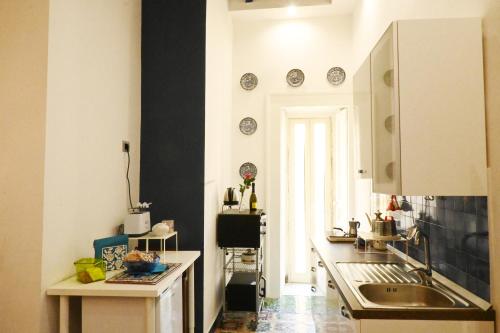 ナポリにあるNanà Bed and Breakfastの黒と白の壁のキッチン(シンク付)
