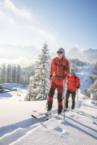 two people are standing on skis in the snow at Dachstein Chalet in Russbach am Pass Gschütt