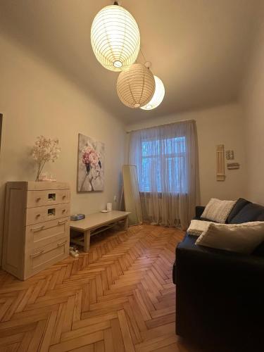a living room with a couch and a dresser and lights at Cozy Apartment- Self Check- In in Riga