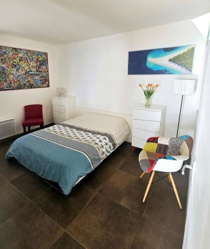 une chambre avec un lit, une table et une chaise dans l'établissement Superbe appartement Vue Mer et Piscine, à Bandol