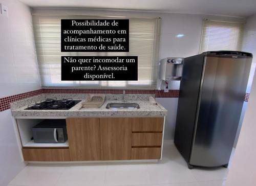 une cuisine avec un réfrigérateur en acier inoxydable et un comptoir dans l'établissement Apto novo, com ar, acesso rápido ao centro, à Uberlândia