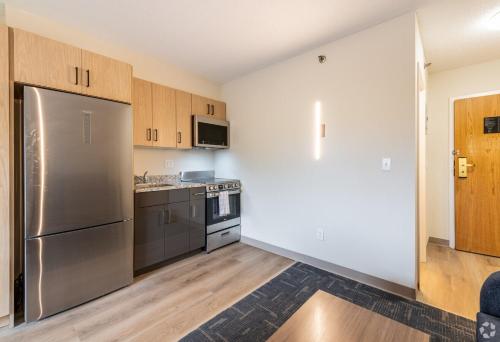 a kitchen with stainless steel appliances and wooden cabinets at Residences at Solomon Pond in Marlborough