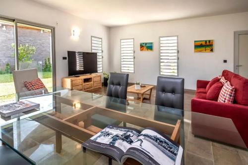 a living room with a glass table and a red couch at Villa with pool in Ramena, sea view in Ramena