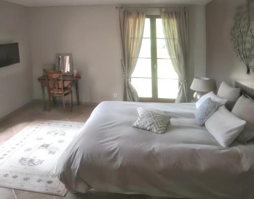 une chambre avec un grand lit blanc avec des oreillers dans l'établissement Villa spacieuse avec piscine à Saint Maximin, à Saint-Maximin-la-Sainte-Baume