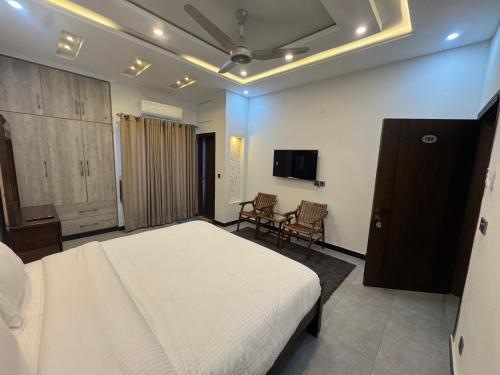 a bedroom with a bed and a flat screen tv at Bridge Residency-2 Top City-1 Islamabad in Islamabad