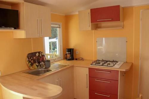 Una pequeña cocina con fregadero y estufa. en Bungalow accueillant à Angles avec piscine partagée, en Angles