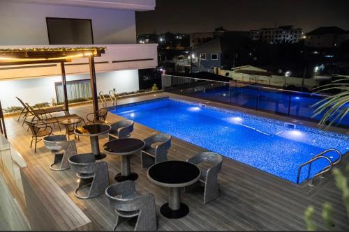 a pool on the roof of a building with tables and chairs at HS Apartment and Duplex in Ogbojo