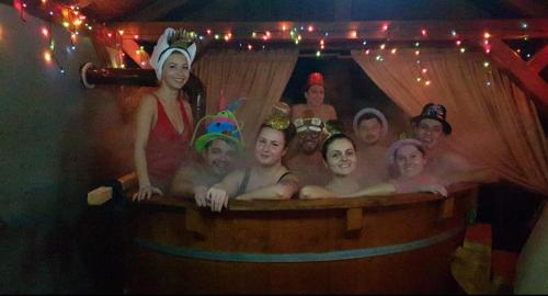 a group of people taking a bath in a wooden bath tub at Pensiunea Rozmarin in Borca