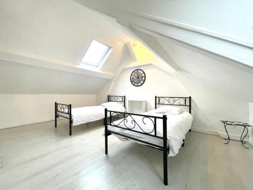 - 2 lits dans une chambre mansardée avec fenêtre dans l'établissement Appartement Atypique Hypercentre, à Rouen