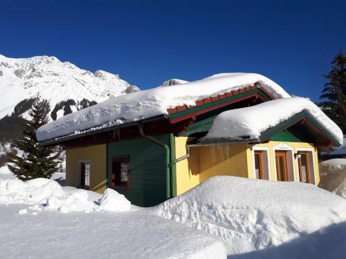 a snow covered house with a snow covered roof at Ramsauer Sonnenalm in Ramsau am Dachstein