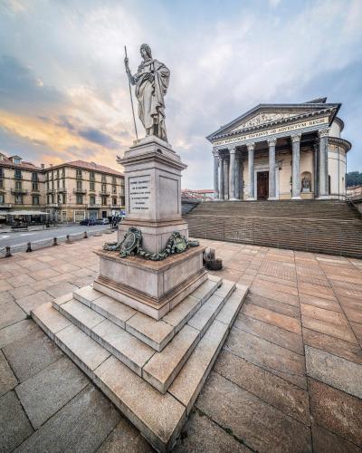 a statue in a square in front of a building at Casa Gran Madre in Turin