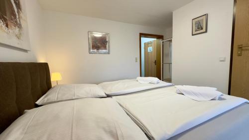 zwei Betten in einem Zimmer mit weißen Wänden in der Unterkunft Aparmtent im Münchner Westen, Parkplatz kostenfrei, ruhig in Gröbenzell