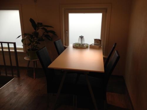 a dining room table with chairs and a window at Vrije Vlinders in IJzendijke
