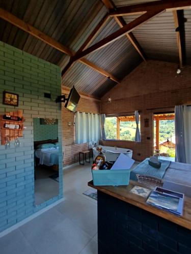 a kitchen and living room with a brick wall at REFUGIO PIEMONTE Chalés in Socorro