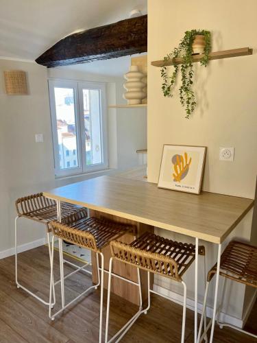 une cuisine avec une table et des chaises en bois dans l'établissement Le Cocon - Studio 3 pers élégant et tout équipé, à Toulon