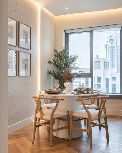 a dining room with a table and chairs and a window at The Boulevard Suite Luxury near Burj Khalifa in Dubai
