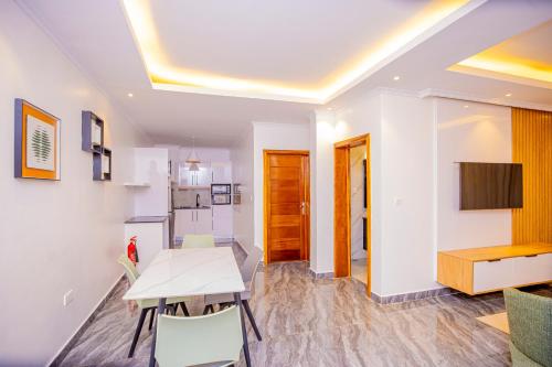 een keuken en eetkamer met een tafel en een keuken en een kamer met bij T-Stone Apartments Kigali-Kimihurura in Kigali