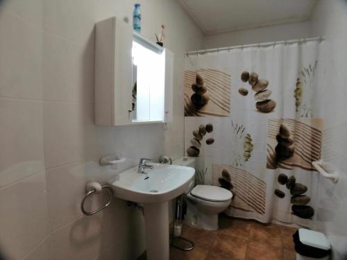 Un baño con lavabo, inodoro y ducha. en Tropicana Park Fase III - TP73 Duplex bungalow, en Denia