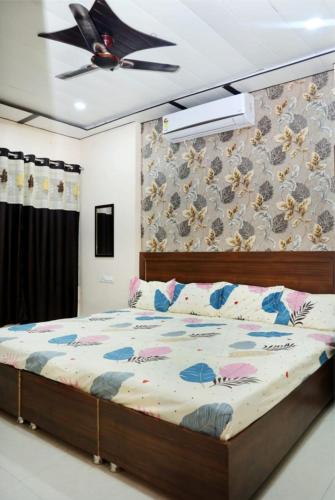 a bedroom with a bed and a ceiling fan at Vidya home stay- 500 mt from Mahakal lok and railway station in Ujjain