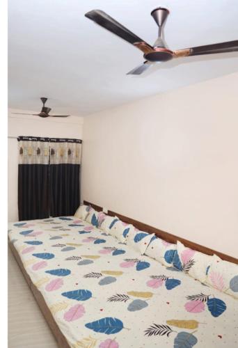 a bed in a room with a ceiling fan at Vidya home stay- 500 mt from Mahakal lok and railway station in Ujjain