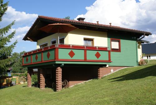 a house with an umbrella on top of a hill at Ramsauer Sonnenalm in Ramsau am Dachstein