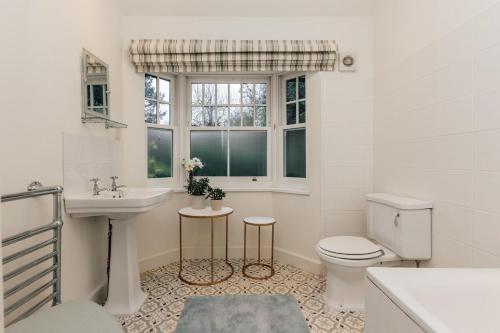a bathroom with a sink toilet and a window at Badgemore Cottage in Henley on Thames