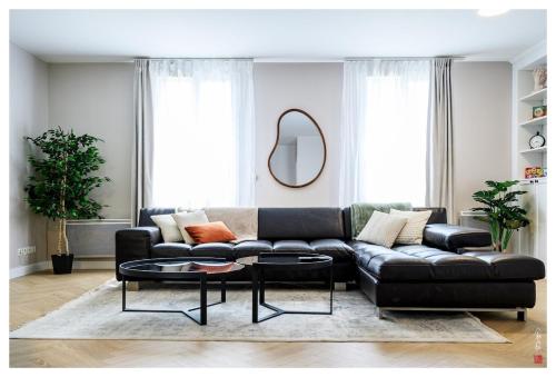 un salon avec un canapé noir et une table dans l'établissement Élégante maison entre Paris et Disney avec parking, à Bailly-Romainvilliers