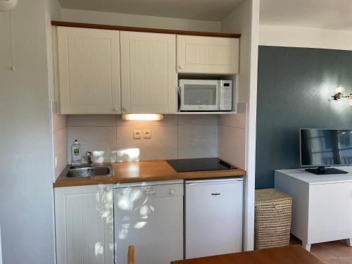 a small kitchen with a sink and a microwave at Parc Arradoy D in Uhart-Cize