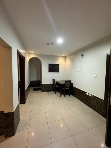 a dining room with a table and a tv on the wall at Al Thanaa Alraqi Furnished Apartments in Jeddah