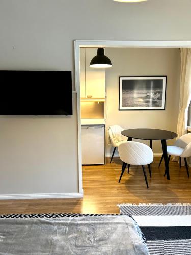 a living room with a table and a tv on a wall at Yksiö Jyväskylässä keskustan tuntumassa in Jyväskylä