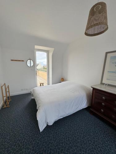 une chambre avec un lit blanc et une fenêtre dans l'établissement Villa Ker Jean, à Brignogan-Plage