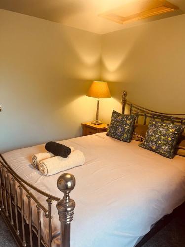 a bedroom with a bed with a lamp on it at Gardener's Cottage in Coldstream Station