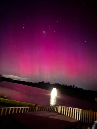 an aurora over a body of water at night at Gardener's Cottage in Coldstream Station