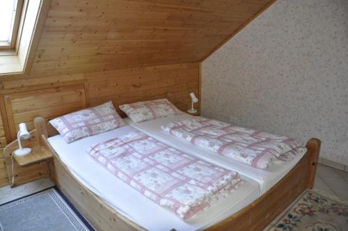 ein Schlafzimmer mit einem Bett in einem Holzzimmer in der Unterkunft Ferienwohnung Anna Scheid in Kelberg