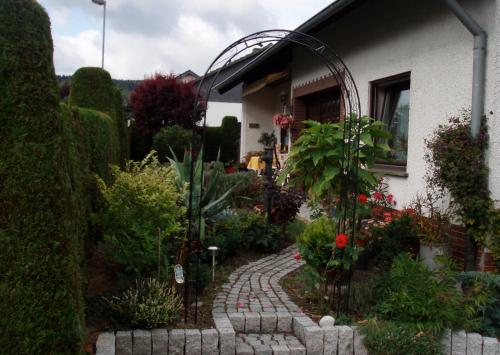 a garden with a brick walkway in front of a house at Ferienwohnung Anna Scheid in Kelberg
