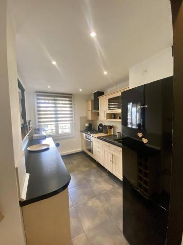 - une grande cuisine avec un comptoir noir dans l'établissement Nice Ouest Caucade- Beautiful 2P, AC, Clim, à Nice