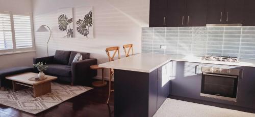 a kitchen and living room with a couch and a table at Beachy Apartment Near Penguin Island - Hosted by Canstay in Rockingham