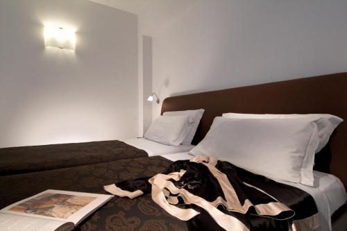 a hotel room with two beds and a book at Best Western Hotel Biri in Padova