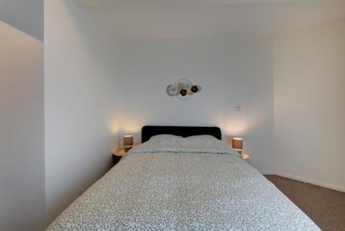 ein Schlafzimmer mit einem Bett in einem weißen Raum in der Unterkunft Appartement Cosy proche Gare in Tours