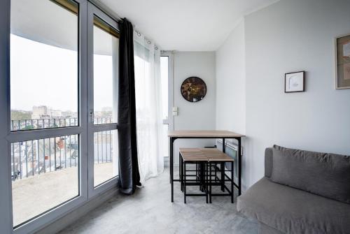 - un salon avec une table, un canapé et une fenêtre dans l'établissement Appartement Cosy proche Gare, à Tours