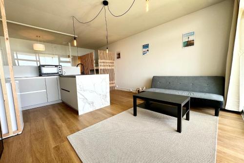 un salon avec un canapé et une table dans l'établissement Appartement Top Cocooning Vue mer 180, à Quiberon