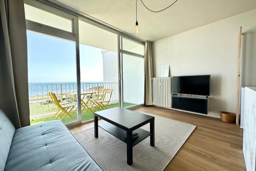 un salon avec un canapé et une grande fenêtre dans l'établissement Appartement Top Cocooning Vue mer 180, à Quiberon
