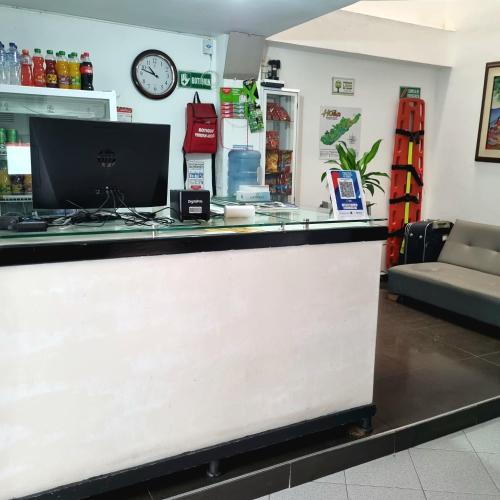 a counter with a computer on top of it at Hotel Iloa in Pitalito